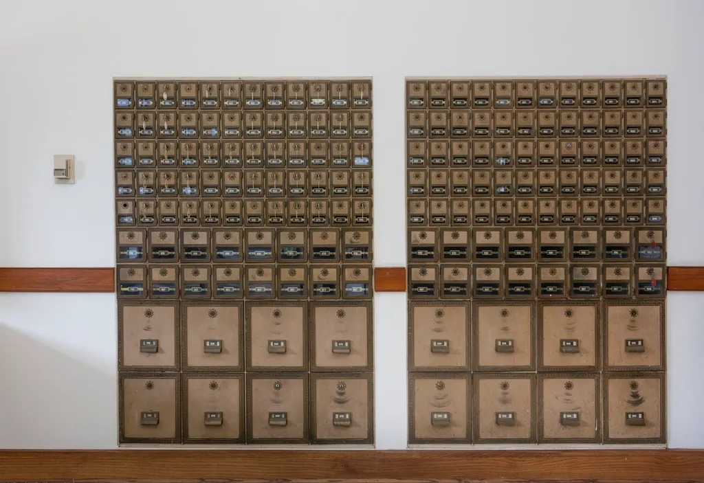 A wall of numbered post office boxes, each with its own lock